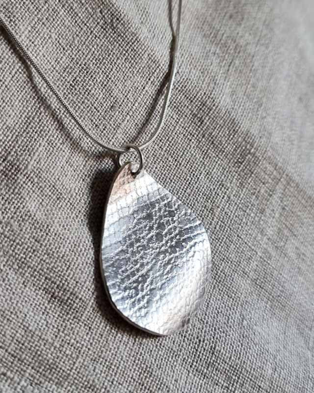 Lace-textured silver pendant